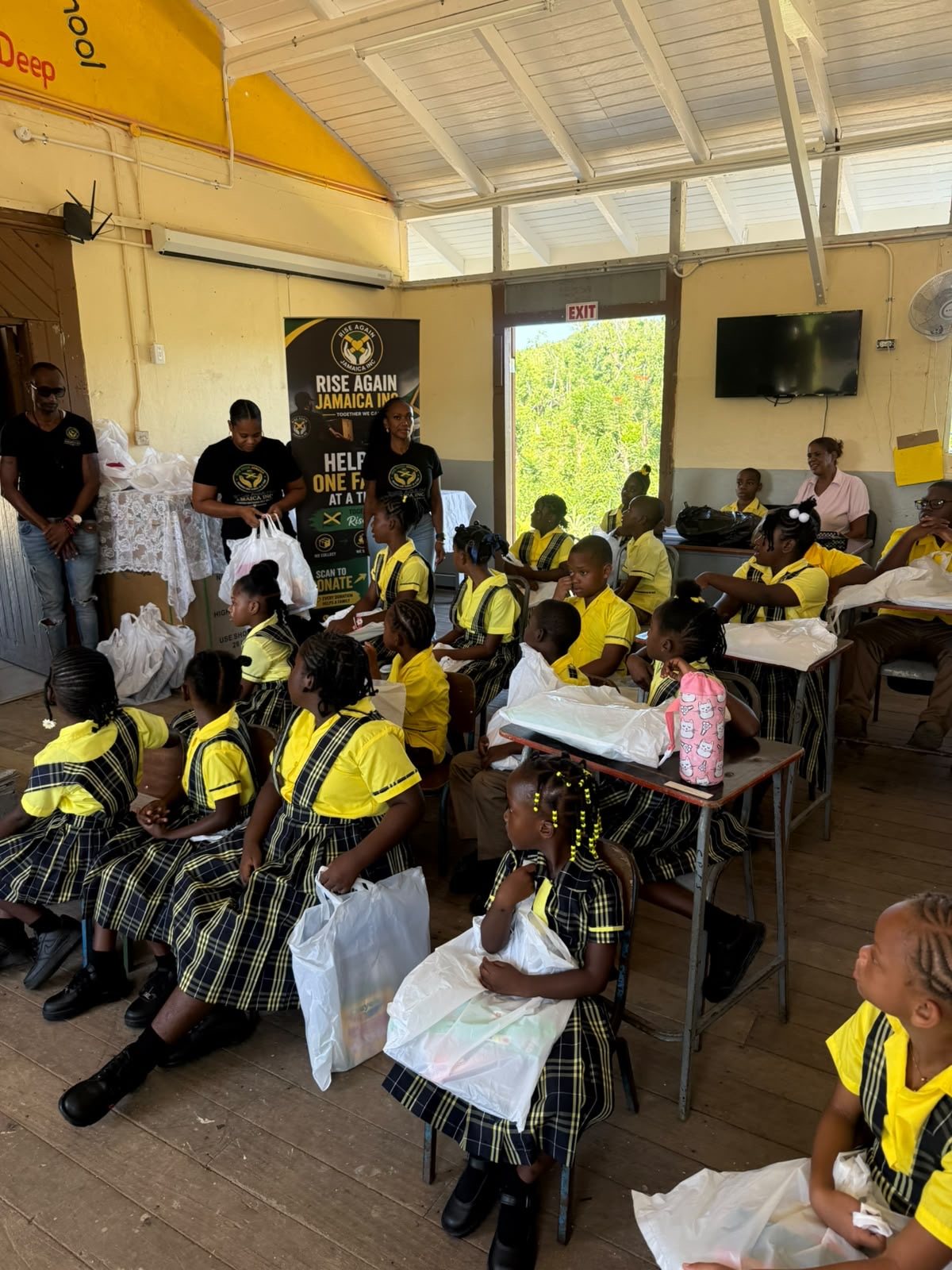Students seated at their desks with back to school supply packages during a Rise Again Jamaica Incorporated distribution.