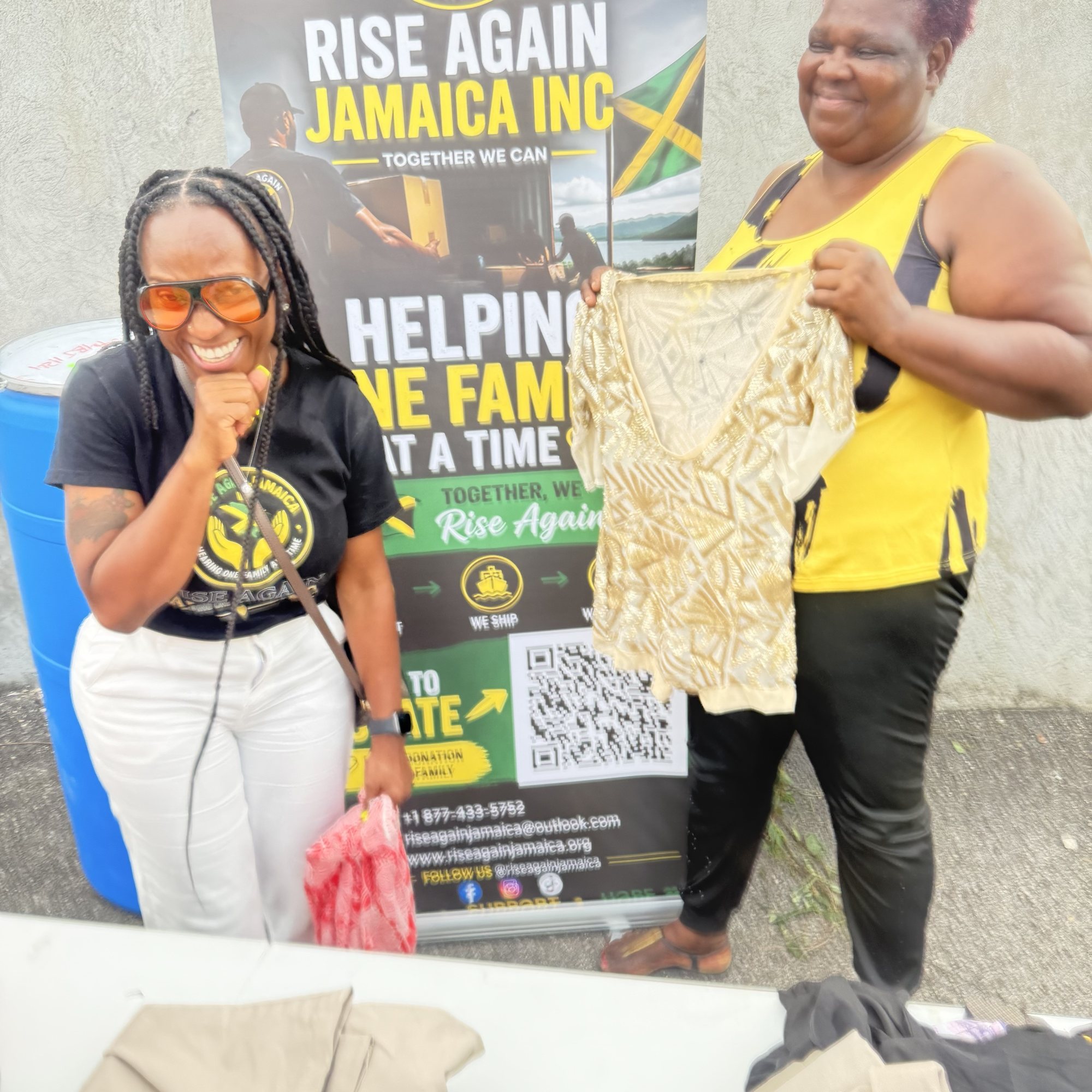 A Rise Again Jamaica Incorporated team member sorting donated clothing with a resident.